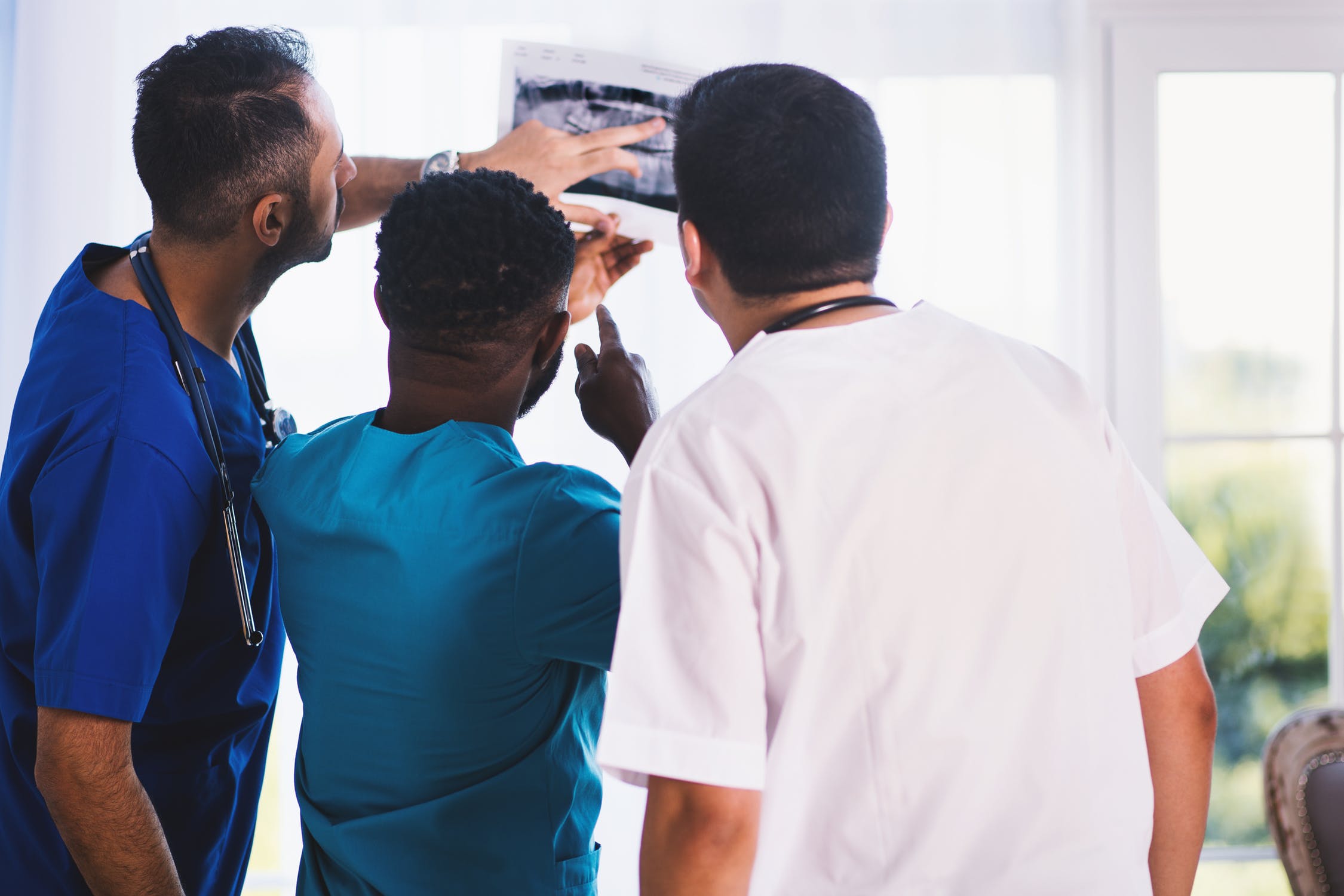 Three doctors analyzing an x-ray